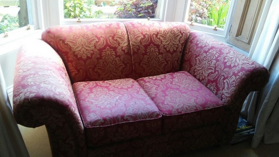 Sofa vải gấm hiện đại với tông màu hồng nhẹ nhàng, được đặt bên cửa sổ là góc nhỏ lý tưởng để thư giãn