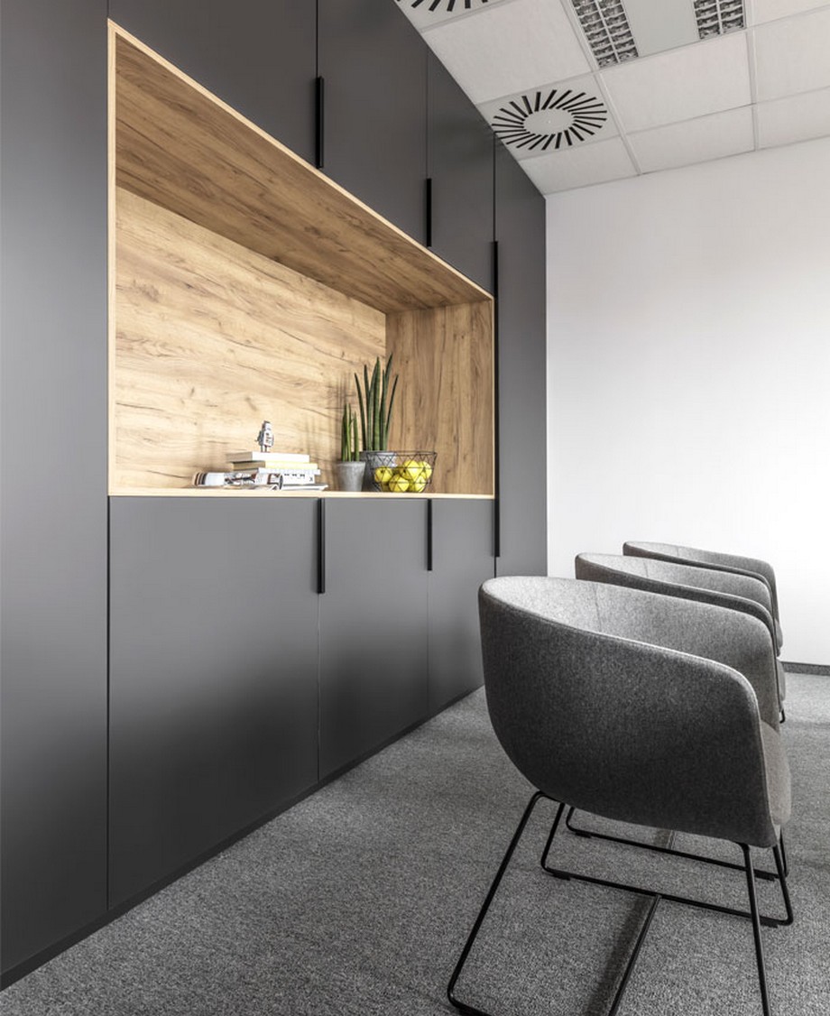 Thiết kế nội thất văn phòng tại Ba Lan phong cách hiện đại với các gam màu pastel ấn tượng > Thiết kế nội thất văn phòng tại Ba Lan với hệ tủ sơn màu đen và ở giữa là khoang gỗ để đồ trưng bày..