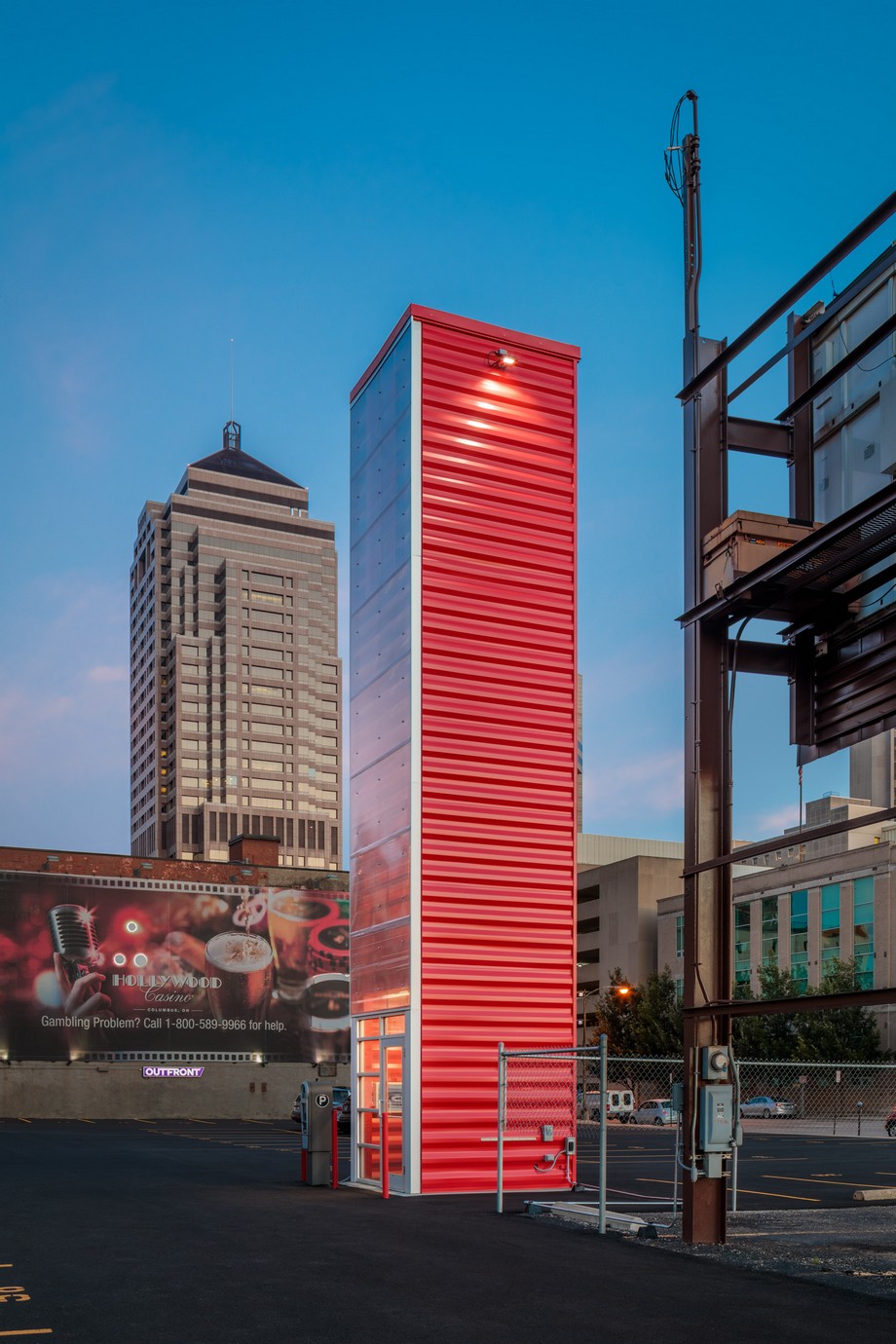 JBAD tái sử dụng container thành bãi đỗ xe thông minh hiện đại > Một mặt của tòa tháp được làm từ kính trong suốt, 3 mặt còn lại là container sơn đỏ